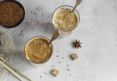 Dalgona köpüklü kahve. Açık gri taşlı arka planda kahve köpüklü Kore içeceği. 