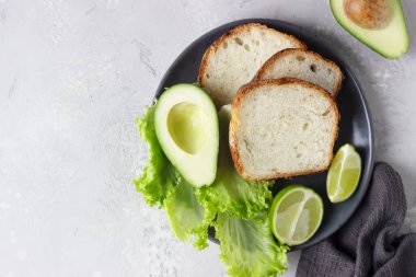 Avokado ile ev yapımı yoğurtsuz ekmek. Mayasız ev yapımı fırın kavramı. Açık gri taş arka plan. Üst görünüm.