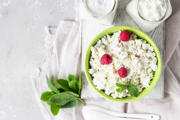 Organic farming cottage cheese with raspberry and mint, sour cream and milk.  Healthy food concept with organic dairy products.