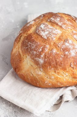 Yuvarlak somun taze desteklenmiş zanaatkar ekşi ekmek. Yoğurt ekmeği yok. Üst görünüm, boşluğu kopyala. Açık gri beton arkaplan.