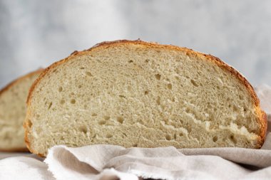 Açık gri taş zemin üzerinde buğday unundan elde edilen zanaatkar rustik ekmek, seçici odaklanma. 