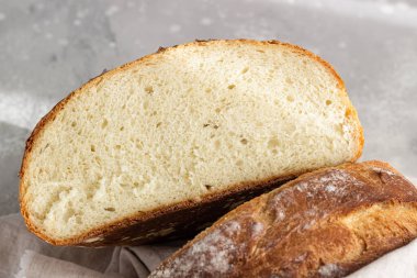 Açık gri taş zemin üzerinde buğday unundan elde edilen zanaatkar rustik ekmek, seçici odaklanma. 