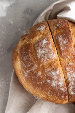 Yuvarlak somun taze desteklenmiş zanaatkar ekşi ekmek. Yoğurt ekmeği yok. Üst görünüm, boşluğu kopyala. Açık gri beton arkaplan.