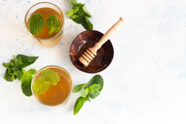 Taze naneli bitki çayı bardaklarda taze nane yaprakları ve açık mavi taş zemin üzerinde bal. Naneli Fas çayı.. 