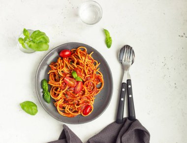 Baharatlı domates soslu, kiraz domatesli ve fesleğenli makarna. İtalyan mutfağı. Üst görünüm.