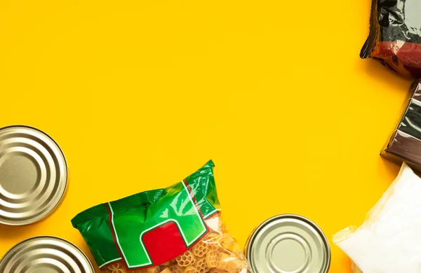 Food donations for quarantine isolation period on yellow background. Food delivery, coronavirus quarantine. Flat lay composition, copy space.