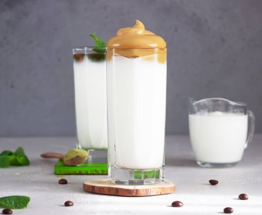 Dalgona kahvesi ve naneli, kremalı ve bambu pipetli bir sütlü kahve. Kore kahvesi trend. 