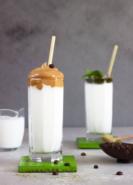 Dalgona kahvesi ve naneli, kremalı ve bambu pipetli bir sütlü kahve. Kore kahvesi trend. 