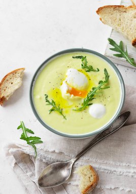 Patates karnabahar çorbası püre garnitür haşlanmış yumurta, zeytinyağı ve roka ile birlikte zanaatkar ekmeği. Vejetaryen sağlıklı gıda konsepti. Açık gri arkaplan. Üst görünüm. 