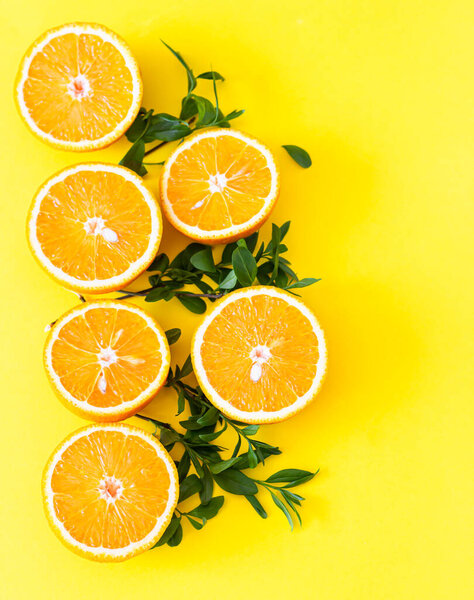 Fresh orange citrus fruit with leaves on yellow paper background. Juicy and sweet fruit. Concentration of vitamin C.