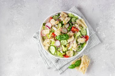 Lezzetli Fatoush veya Arap salatası Pita ekmeği, taze sebzeler ve tabakta fesleğen. Orta Doğu ekmek salatası. Üst görünüm.
