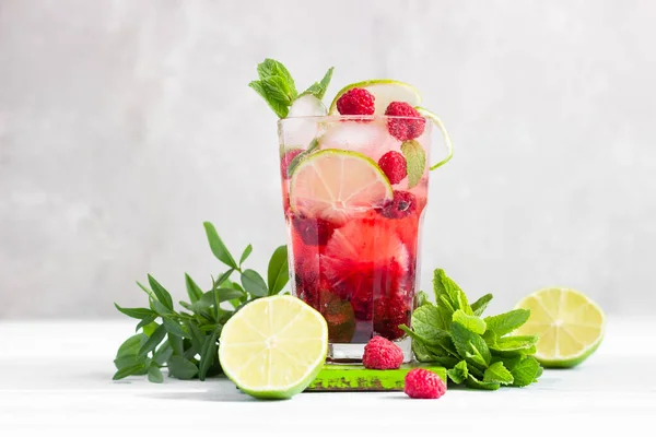 Limonata ya da alkolsüz kokteyl, ahududu, limon ve gri arka planda naneli. Yaz meyveli içeceği.
