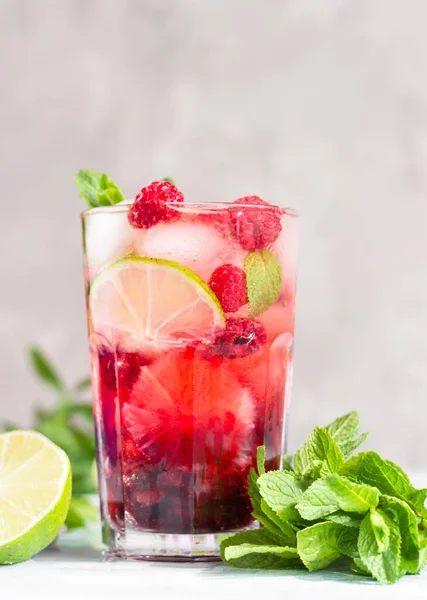 Limonata ya da alkolsüz kokteyl, ahududu, limon ve gri arka planda naneli. Yaz meyveli içeceği.