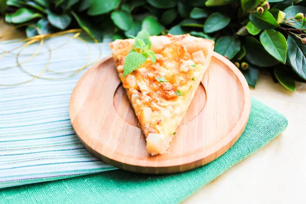 Homemade puff pastry pie or pizza with camembert cheese, conference pears, walnuts and fresh mint, selective focus. Picnic and snack food. Breakfast food. Summer food. Idea for snack pizza pie.