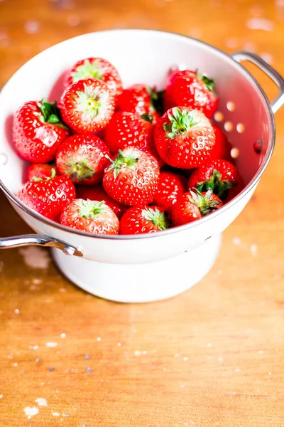 Fresh ripe juicy strawberry harvest or crop in a white colander