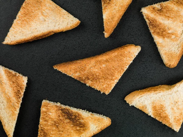 Desen siyah bir arka plan karşı kızarmış ekmek — Stok fotoğraf