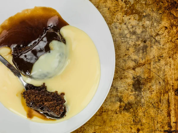 Sticky Toffee Pudding Dessert geserveerd met warme vanillesaus — Stockfoto