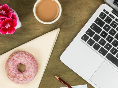 Donut bir bilgisayar iş istasyonu ile bir fincan çay Iced