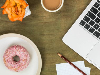 Donut bir bilgisayar iş istasyonu ile bir fincan çay Iced