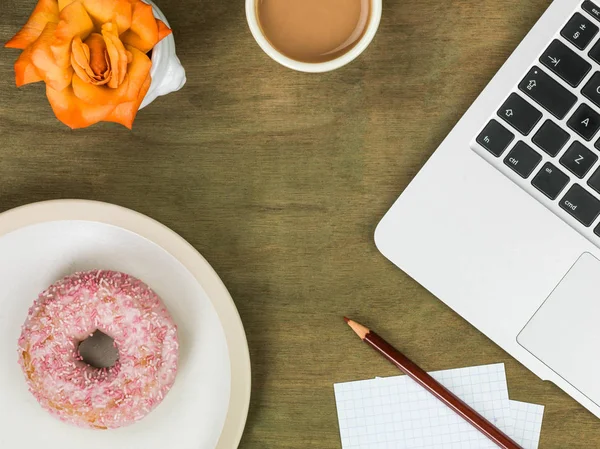 Donut bir bilgisayar iş istasyonu ile bir fincan çay Iced