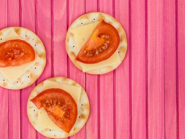 Cheese and Tomato on Water Biscuit Crackers Stock Picture