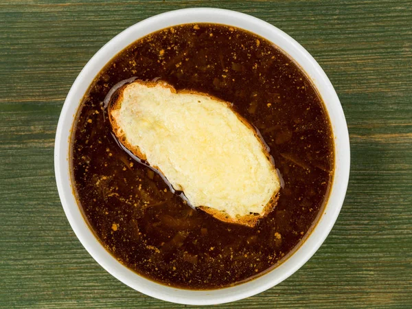 Kom van Franse uiensoep met geroosterd brood en gesmolten kaas — Stockfoto