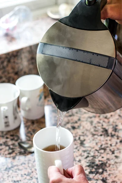 Bir fincan çay ya da kahve bir su ısıtıcısı dökme