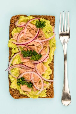 Ton balığı ve avokado siyah ekmek üzerinde soğanlı yüz sandviç açın