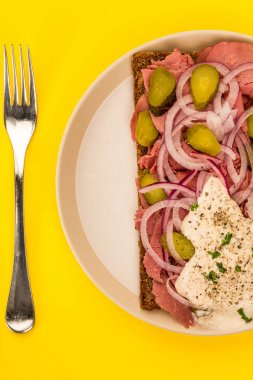 Fırında etli açık yüzlü sandviç dilimlenmiş soğan turşusu ve Horseradish sos ile