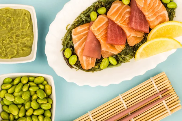 Rodajas de estilo japonés de salmón y atún sashimi en una cama de algas marinas picadas —  Fotos de Stock