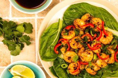 Fried Çince biber karides buğulanmış Pak Choi Yeşiller yatağı üzerinde stil. 