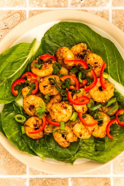 Gamberetti di peperoncino fritti in stile cinese su un letto di verdure al vapore Pak Choi — Foto Stock