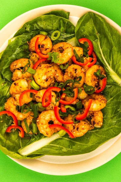 Gamberetti di peperoncino fritti in stile cinese su un letto di verdure al vapore Pak Choi — Foto Stock