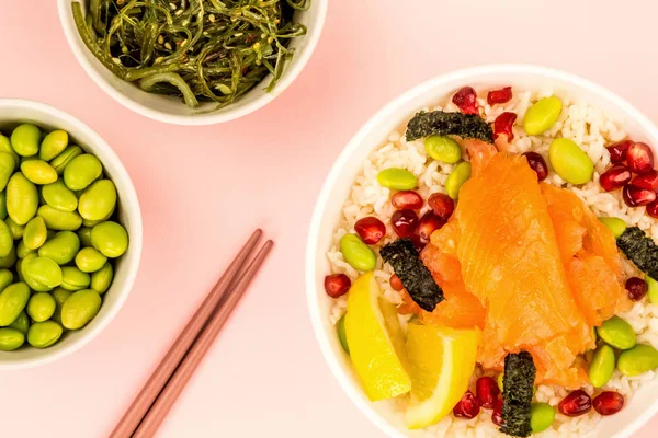 Healthy Hawaiian Style Poke Bowl Of Smoked Salmon With Rice Edamame beans Seaweed and Pomegranate Seeds Stock Image