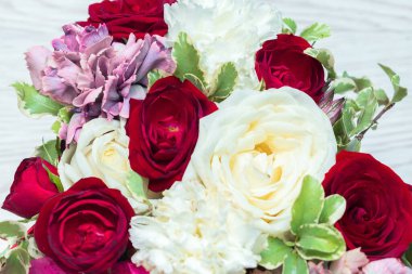 Beyaz ahşap masadaki hediye kutusunda kırmızı ve beyaz güller. Çiçek makrosu. Bahar arkaplanı.