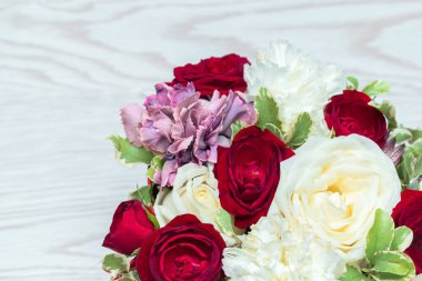 Beyaz ahşap masadaki hediye kutusunda kırmızı ve beyaz güller. Çiçek makro pankartı. Bahar çiçeği arkaplanı.