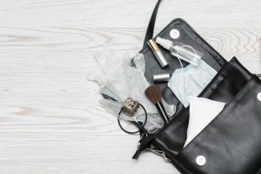 Bakteri bulaşmasını önlemek için antibakteriyel el dezenfektanı, tıbbi maske, eldiven ve peçeteyle kadın çantası düzleştirilmiş. Enfeksiyonlardan kaçınmak için kişisel hijyen kavramı Corona virüsü, kopyalama alanı.