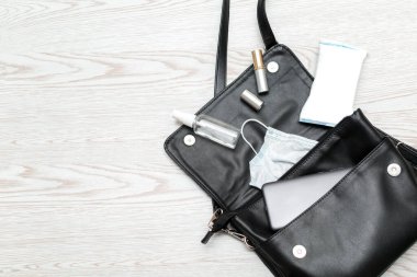 Kadın çantasına antibakteriyel dezenfektan, tıbbi maske, peçete ve telefon koyun. Bakterilerin korunması yayılır. Enfeksiyonlardan kaçınmak için kişisel hijyen kavramı. Kopya alanı olan Corona virüsü.