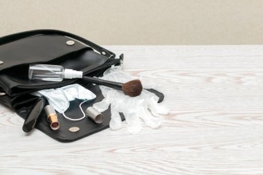 Bakteriyel antibakteriyel el dezenfektanı, tıbbi maske ve bakteri bulaşmasını önlemek için eldivenle kadının çantasını kapat. Enfeksiyonlardan korunmak için hijyen kavramı..