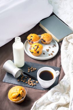 Kahvaltı için siyah tepsi, bir fincan kahve ve sütlü kek. Karantina konseptinde evde güvende kal..