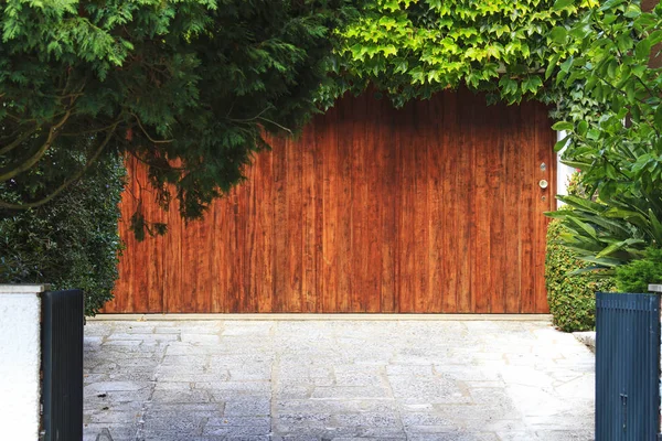 Wooden door from the garage and green garden — Stock Photo, Image