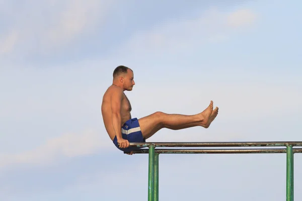 Cara jogando esportes em barras paralelas — Fotografia de Stock