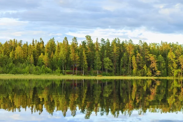 Место для душевного спокойствия, дом в лесу и лодка на озере — стоковое фото