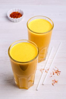 Ahşap arka planda cam kaplı sarı smoothie. Seçici odak.