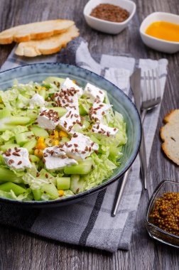 Tahta arka planda beyaz peynir ve keten tohumlu sebze salatası. Seçici odak.