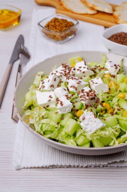 Tahta arka planda beyaz peynir ve keten tohumlu sebze salatası. Seçici odak.