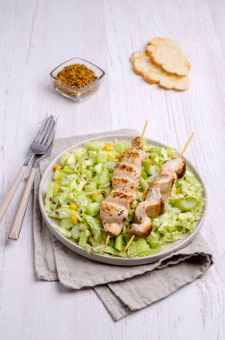 Ahşap bir arka planda çiğ sebze salatasıyla kebap eti. Seçici odak.