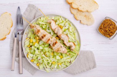 Ahşap bir arka planda çiğ sebze salatasıyla kebap eti. Seçici odak.