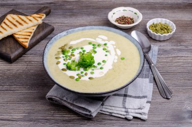 Ahşap arka planda beyaz soslu kalın sebze kremalı çorba. Seçici odak.