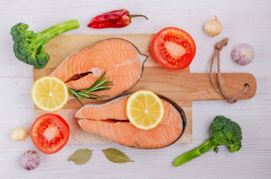 Ahşap arka planda sebze ve baharatlı çiğ organik somon bifteği. Seçici odak.